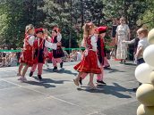 Dzieci tańczą jeden z kroków tańca krakowiak.