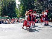 Dzieci w strojach krakowskich tańczą krakowiaka.