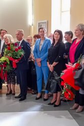 II Małopolska Wicekurator Oświaty Katarzyna Mitka stoi wśród osób, które trzymają kwiaty.