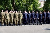 Część uczniów szkoły stojących na baczność w rzędzie, ubranych w swoje tradycyjne stroje.