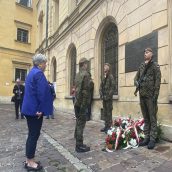 Małopolska Kurator Oświaty dr Gabriela Olszowska podczas składania pamiątkowego wieńca pod tablicą. Przed nią stoją żołnierze w umundurowaniu