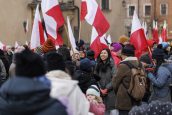 Widok publiczności zgromadzonej podczas obchodów, niektórzy trzymają biało-czerwone flagi.