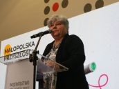 Małopolska Kurator Oświaty dr Gabriela Olszowska stojąca na scenie i przemawiająca do zgromadzonej młodzieży w ramach otwarcia uroczystości