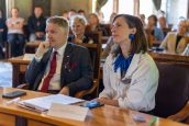 I Małopolski Wicekurator Oświaty oraz wiceprezydentka Krakowa siedzą obok siebie na fotelach i słuchają wykładu. Na biurku dwa telefony oraz notatki.