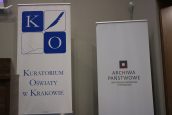 Zdjęcie przedstawiające dwa banery reklamowe umieszczone w sali - jeden z nich jest Kuratorium Oświaty, drugi Archiwum Narodowego.