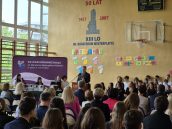 I Małopolski Wicekurator Oświaty Artur Pasek w trakcie swojego wystąpienia w ramach zakończenia roku, na bliższym planie słuchający go uczniowie.