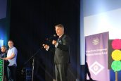 I Małopolski Wicekurator Oświaty Artur Pasek stojący na scenie i przemawiający do zgromadzonych osób w sali Kina Kijów w trakcie wydarzenia.