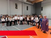 Małopolska Kurator Oświaty we wspólnym, grupowym zdjęciu wraz z uczniami i uczennicami w sali gimnastycznej, gdzie odbywało się zakończenie roku szkolnego.