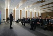 I Małopolski Wicekurator Oświaty na scenie, przed nim zgromadzeni goście, słuchający jego przemówienia.
