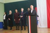 Minister Kiepura wraz z Małopolskimi Wicekuratorami Oświaty oraz Dyrektorką Szkoły w trakcie przemówień na sali gimnastycznej, gdzie odbywała się lekcja obywatelska.