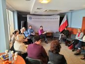 Wicekurator Katarzyna Mitka siedzi przy biurku. Wokół siedzą pozostali uczestnicy spotkania. W tle widoczna flaga Polski oraz ścianka z napisem Kuratorium Oświaty w Krakowie.