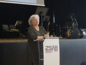 MKO dr Gabriela Olszowska w trakcie swojego wystąpienia, stoi przed mikrofonem i przemawia. Za nią ustawiona scena.