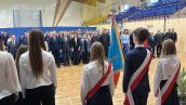 Zaproszeni goście, w tym Małopolski Wicekurator Oświaty stoją w rzędzie na baczność, przed nimi uczniowie ze Sztandarem Szkoły.