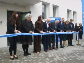 Oficjalne przecięcie wstęgi przed budynkiem, przez zaproszonych gości.