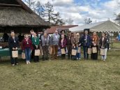 II Małopolska Wicekurator Oświaty Katarzyna Mitka wraz z zaproszonymi gośćmi podczas zdjęcia grupowego. Goście trzymają upominki.