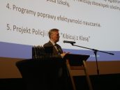 I Małopolski Wicekurator Oświaty Artur Pasek na scenie, w trakcie swojego wystąpienia, przemawiający do mikrofonu.