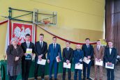 MKO wraz z uczniami we wspólnym zdjęciu. Osoby stoją w jednym rzędzie, uczniowie trzymają dyplomy.