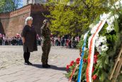 MKO składająca kwiaty w trakcie uroczystości. Na bliższym planie m.in biało-czerwone wieńce