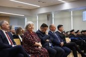Zaproszeni goście, w tym MKO siedzą na krzesłach i obserwują wydarzenia na scenie. MKO zwrócona w stronę fotografa.