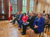 Zaproszeni goście, w tym Małopolski Kurator Oświaty oraz Wicewojewoda Małopolska siedzą na krzesłach, zwróceni w stronę sceny.