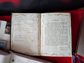 Pamiątkowe księgi z m.in. wpisami okolicznościowymi. Księgi ustawione na stole obok nich długopisy.