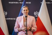 Ministra Edukacji Barbara Nowacka w trakcie swojego wystąpienia. Za nią flagi m.in Polski.