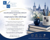 Oficjalne życzenia Małopolskiego Kuratora Oświaty, dr Gabrieli Olszowskiej, z okazji rozpoczęcia roku szkolnego 2026/2027. W lewym górnym rogu znajduje się logo Kuratorium Oświaty w Krakowie (litery K i O z ikoną pióra i książki). Pod logo umieszczono nagłówek: „ŻYCZENIA MAŁOPOLSKIEGO KURATORA OŚWIATY z okazji rozpoczęcia roku szkolnego 2026/2027”. Treść życzeń: Adresaci: „Szanowni Dyrektorzy, Nauczyciele, Pracownicy Oświaty, Drodzy Uczniowie, Rodzice i Opiekunowie,” Tekst: „Z okazji rozpoczęcia roku szkolnego 2026/2027 życzę Państwu wielu sukcesów, satysfakcji z podejmowanych wyzwań oraz nieustającej motywacji do zdobywania wiedzy i rozwijania pasji. Niech nadchodzący rok szkolny będzie czasem inspiracji, owocnej współpracy i wzajemnego wsparcia, a szkoła miejscem bezpiecznym, przyjaznym i otwartym na każdego ucznia. Życzę wszystkim zdrowia, wytrwałości, sukcesów oraz wielu powodów do radości każdego dnia!”Podpis: „Małopolski Kurator Oświaty dr Gabriela Olszowska” (wraz z pisemnym podpisem). Po prawej stronie widoczny jest stos książek, ciemnoniebieskie jabłko oraz kubek z przyborami do pisania i logo Kuratorium. W tle rozmyty widok na krakowskie zabytki. Na dole znajduje się granatowy pas z czterema ikonami i hasłami: WIEDZA, WSPÓŁPRACA, SZACUNEK, ROZWÓJ oraz hasło: „RAZEM TWORZYMY PRZYSZŁOŚĆ MAŁOPOLSKIEJ EDUKACJI”.